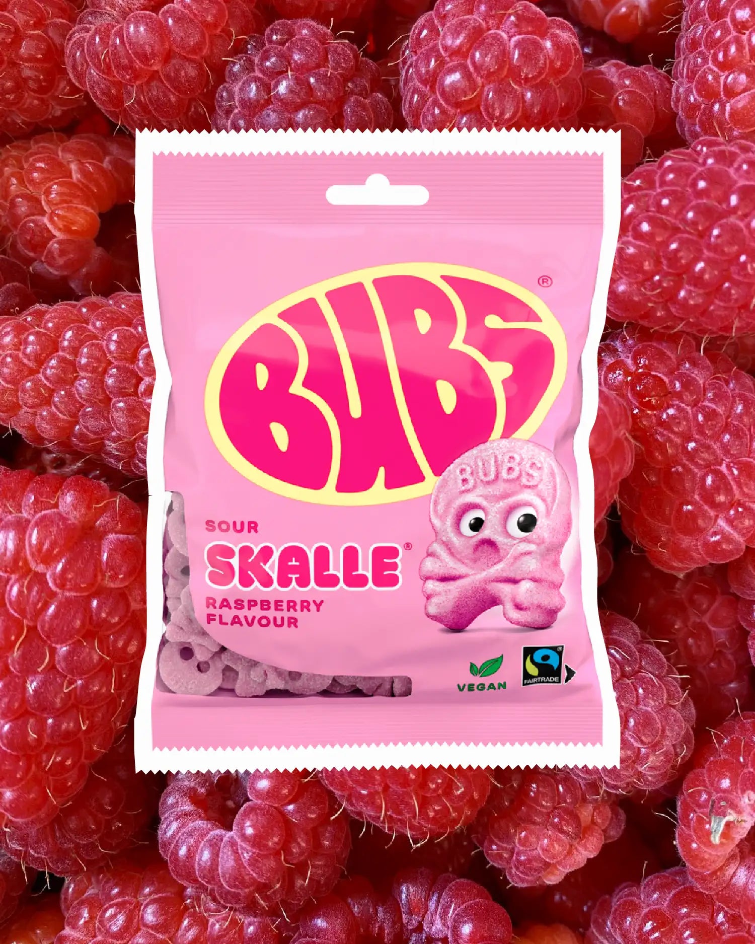 BUBS Swedish candy skull - vegan sour raspberry flavor bag on a background of raspberries 